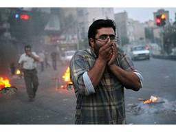 Passersby are overcome by the fumes from burning shithead in the streets of Tehran.
